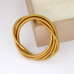 Detail of 18K gold-plated multi-layer coiled snake bone bracelet on jewelry box