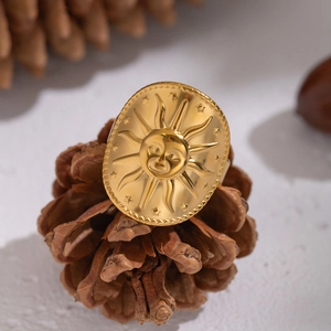Detail of vintage 18K gold sun face embossed ring on pinecone with polished texture