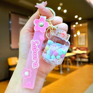 Close-up of pink Sakura oil-filled shaker bottle keychain with silicone wristband strap
