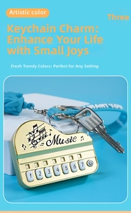 Macro shot of golden piano keychain with musical notes and blue WANT YOU silicone strap