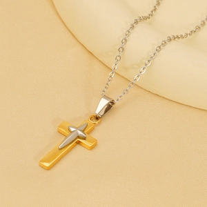 Retro cross pendant necklace in 18K gold and silver stainless steel on fabric background