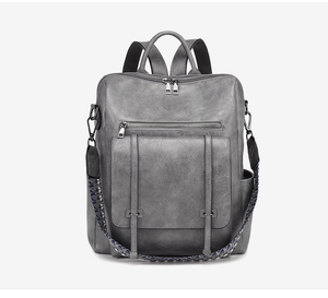 Detail of dark grey PU leather backpack with vintage texture and woven strap