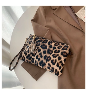 Detail of leopard print clutch featuring a stylish fringe tassel and gold zipper