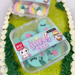 Close-up of cute cloud-shaped erasers in a storage box on a green grass textured background