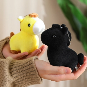 Close-up of cute plush horse keychains in yellow and black with metal chains