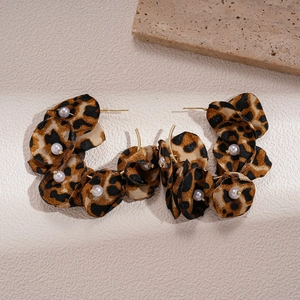 Close-up of leopard print fabric flower earrings with faux pearls and gold hardware