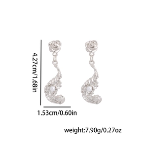 Vue détaillée des boucles d'oreilles rose argentée avec texture vague, perles et taille