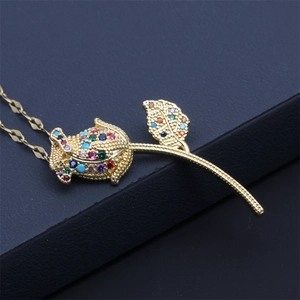 Macro view of golden rose pendant with colorful gemstones on a minimalist fine chain