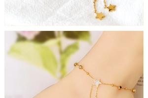 Detail of gold star and tassel anklet featuring black and white zircon stone inlay