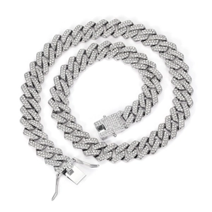 Close-up of silver Cuban link necklace with sparkling crystals on white background