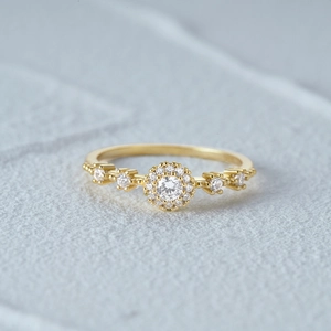Macro shot of a luxury gold halo ring with white diamonds and sparkling claw setting