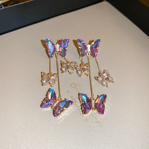 Elegant gold butterfly drop earrings featuring purple crystals and sparkling diamonds