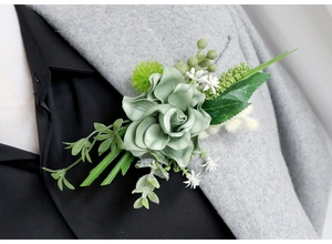 Close-up of Morandi green silk rose boutonniere with realistic berries and foliage