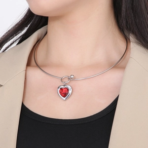 Polished steel choker necklace featuring a faceted red heart stone pendant on a model