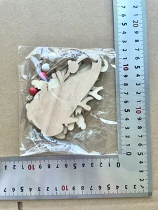 Detailed view of wooden Christmas ornaments with red beads and measuring scale