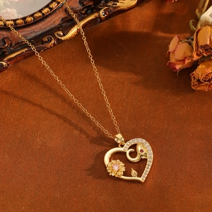 Collier pendentif cœur doré avec motifs éléphant et tournesol et zircons roses sertis