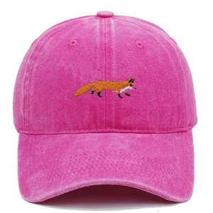Detailed close-up of fox embroidery on pink washed cotton baseball cap texture
