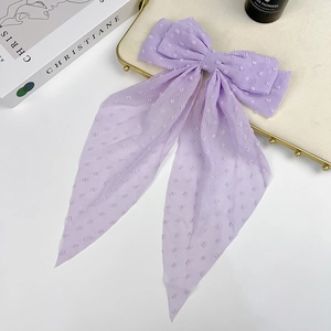 Detail of light purple chiffon bow hair clip with textured polka dots and long ribbons