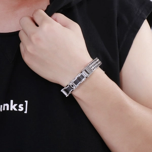 Close-up of men's stainless steel bracelet with black carbon fiber inlay on wrist