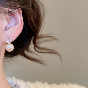 Detail view of 10mm pearl earring with zircon inlay worn on the ear for a vintage look