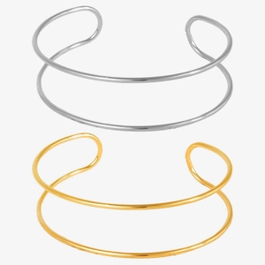 Detailed close-up of double-layer minimalist C-shaped open bracelets in gold and silver