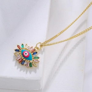 18K gold plated copper Evil Eye necklace with colorful zircon stones on stone surface