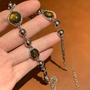 Sleek silver metal bead bracelet featuring golden brown cat eye stones and extender chain