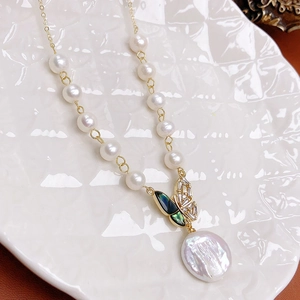 Macro shot of natural freshwater pearls necklace with zircon butterfly and baroque pearl
