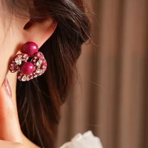 Vintage irregular flower earrings with pink beads and zircons on a female model