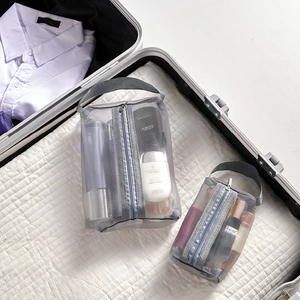 Organisateurs de voyage en filet gris dans une valise avec maquillage et produits