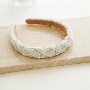Detail of tweed fabric texture and brown lining on a padded wide headband accessory