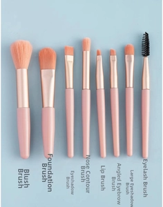 Detail of 8pcs pink makeup brush set including blush and eye brushes on blue background