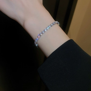Gros plan d'un élégant bracelet en perles et papillon plaqué or sur le poignet d'un mannequin
