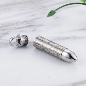 Detailed macro view of silver bullet pendant with engraved Lord’s Prayer on polished steel