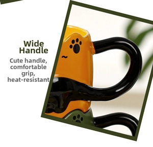 Detail shot of the thick ergonomic handle and paw print on yellow and green ceramic mugs