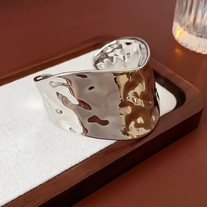 Vue macro détaillée du large bracelet jonc argenté avec texture fluide irrégulière