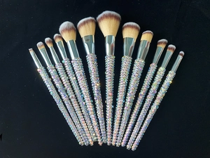 Detail of 12 luxury makeup brushes with rainbow rhinestones on professional black background