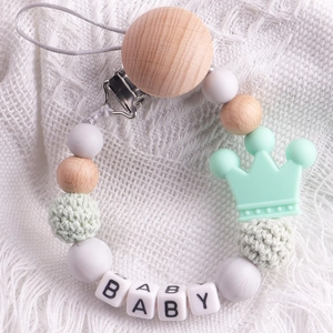 Detail of beech wood pacifier clip with mint green silicone beads and BABY crown design