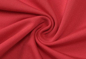 Makroaufnahme von rotem Rippstrickgewebe mit Details zum gefalteten Spiraldesign