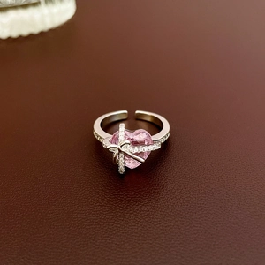 Detailed macro view of pink heart zircon ring with silver cross and pave crystal setting