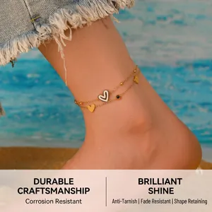 Detail of double-layer gold anklet with heart pendants on a beach background