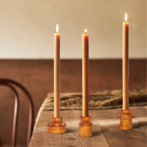 European minimalist amber ribbed glass candle holders set with burning taper candles