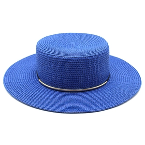 Dettaglio cappello in paglia blu con corona piatta e sottile fascia in metallo dorato