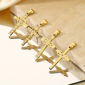 Vue détaillée de quatre pendentifs croix en or 18k avec nœuds sur marbre poli