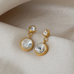Gros plan de boucles d'oreilles pendantes plaquées or avec zircons sur fond de soie
