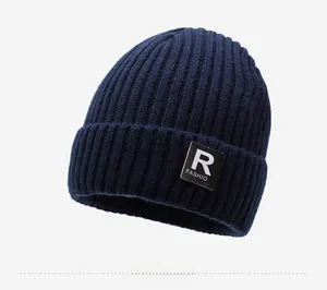 Detailed texture of dark blue knit beanie showing thick rib pattern and fashion patch label