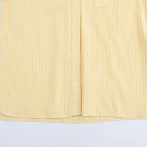 Close-up of yellow and white vertical striped shirt showing buttons and fabric texture