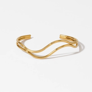 Minimalist double-layer wavy gold cuff bracelet featuring a sleek open adjustable design