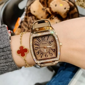 Close-up of a women's quartz watch with a crystal-encrusted gold rectangular bezel