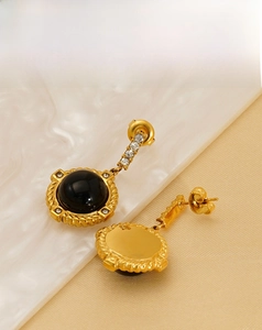 Détails de boucles d'oreilles vintage en or avec pierres noires et petits diamants